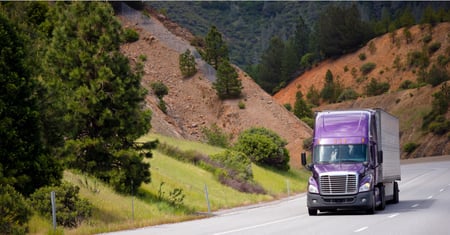 lilac truck driving near mountain